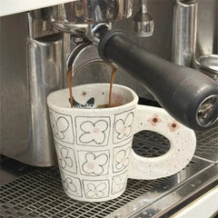 Splashing ink, hand pinching ceramic coffee cup